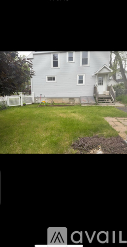 A house with a grey facade and a white fence.