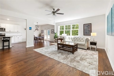 A living room with a white couch and a rug.