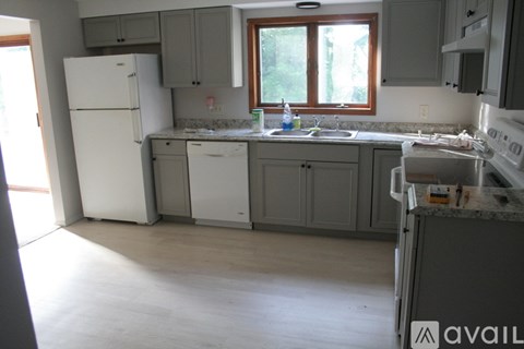 A kitchen with a white refrigerator and a window.