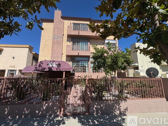 A building with a purple awning is in front of a tree.