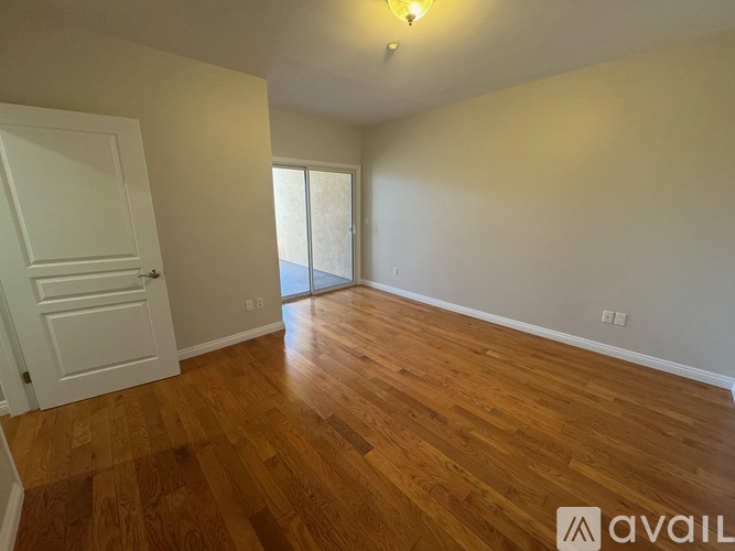 A room with wooden flooring and a white door.