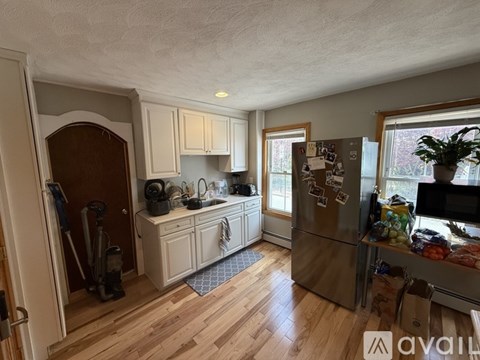 A kitchen with wooden floors and a refrigerator.