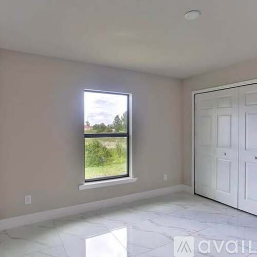 A room with a large window and a white door.