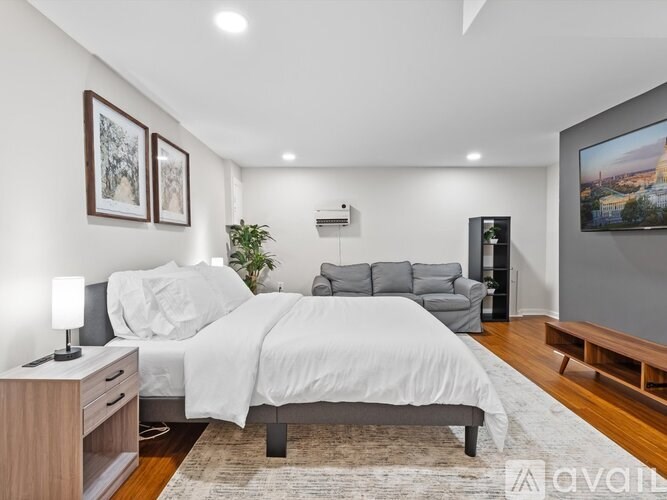 A bedroom with a large bed, a couch, and a television.