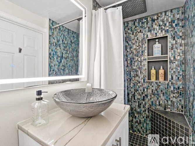 A bathroom with a white sink and a shower with a white curtain.
