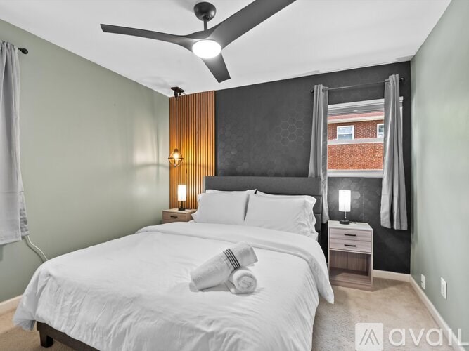 A bedroom with a large bed and a ceiling fan.