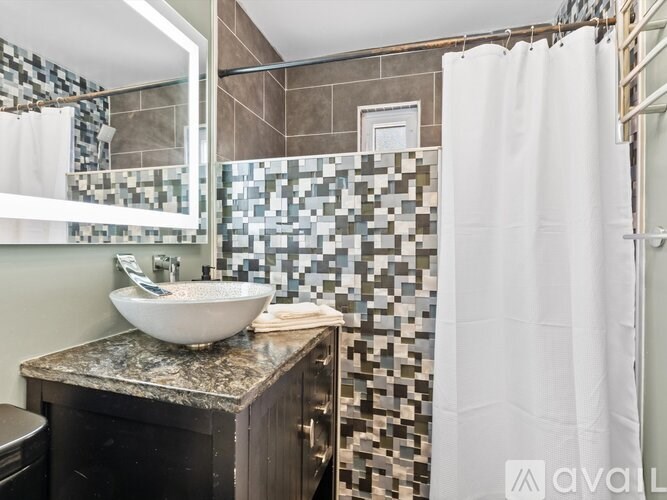 A bathroom with a white sink and a shower curtain.