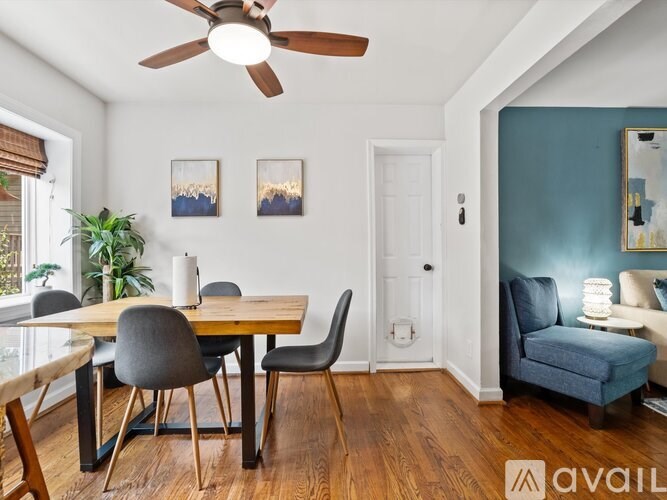 A room with a dining table and chairs, a couch, and a ceiling fan.