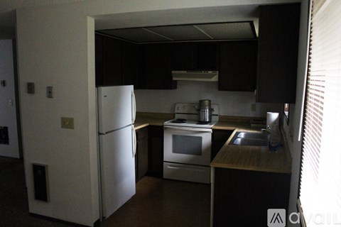 A kitchen with a white refrigerator and stainless steel appliances.