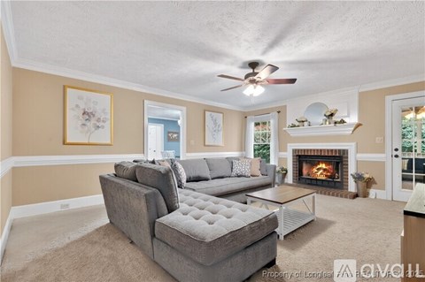 A living room with a grey couch and a fireplace.
