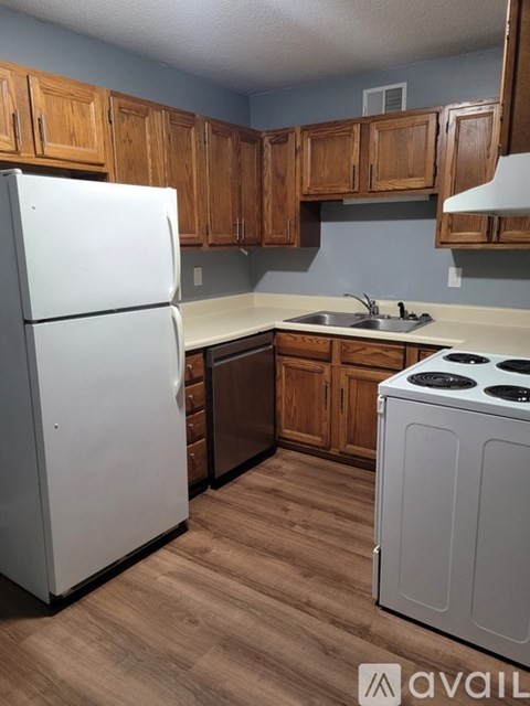 A kitchen with a white refrigerator and a white stove top oven.