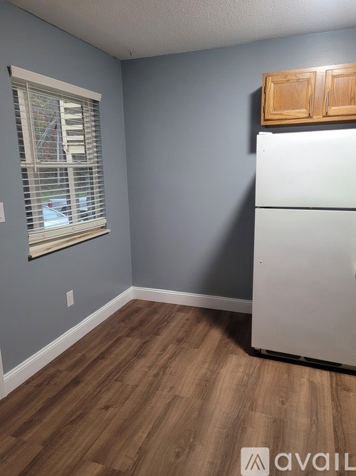 A kitchen with a white refrigerator and wooden cabinets.