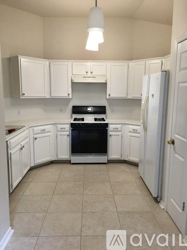 A kitchen with white cabinets and a black stove top oven.