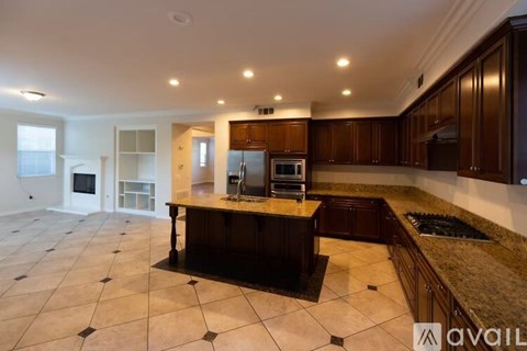 A kitchen with brown cabinets and a granite countertop.