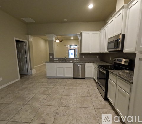 A kitchen with white cabinets and a tiled floor.