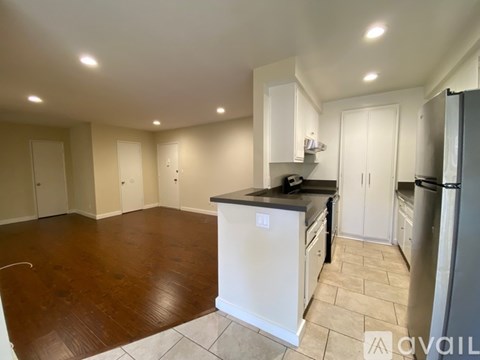 A kitchen with white cabinets and a black countertop.