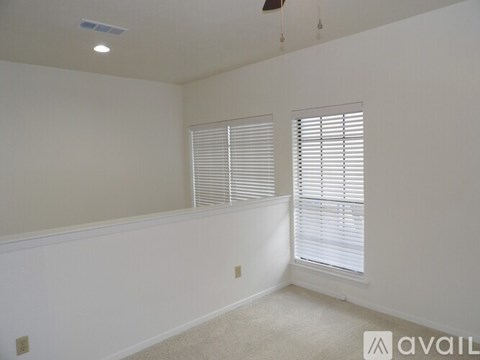 A room with a window covered by white blinds.