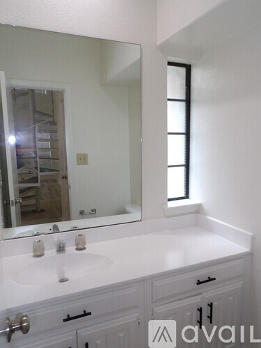 A bathroom with a white sink and a mirror.