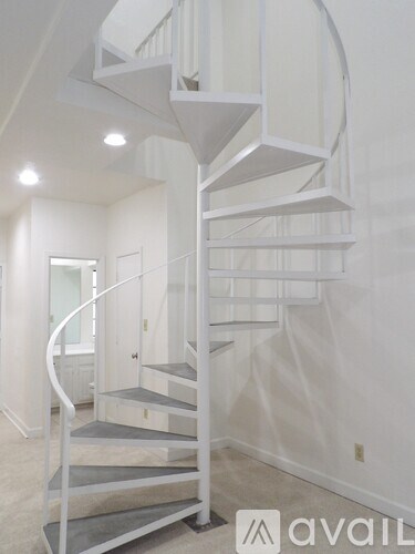A white spiral staircase in a room.