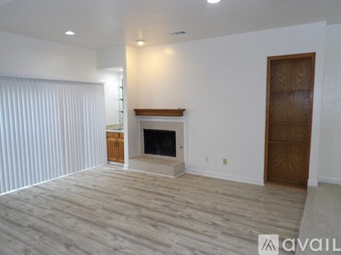 A spacious living room with a fireplace and a wooden door.