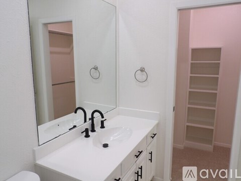 A bathroom with a sink, mirror, and toilet.