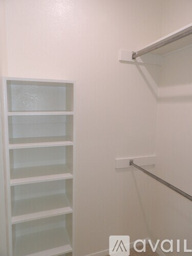 A white shelving unit with glass panels is mounted on a white wall.