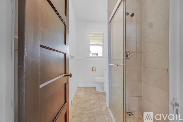 A bathroom with a toilet, sink, and shower.
