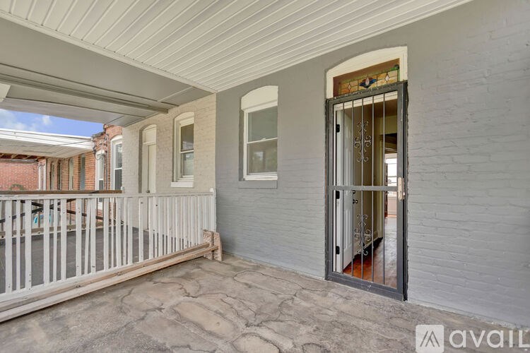 A balcony with a white railing and a door with a glass window.