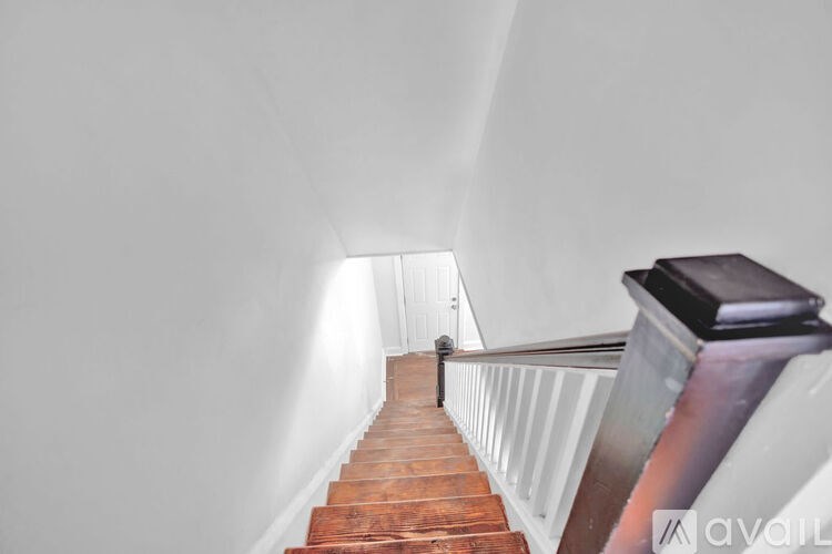 A staircase with a wooden handrail and a metal balustrade.