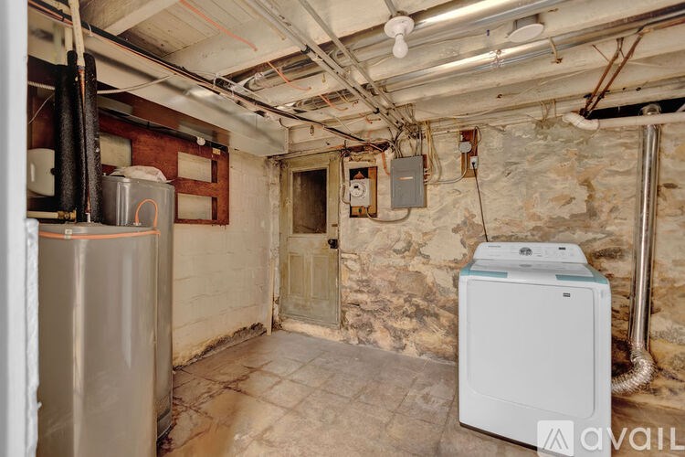 A dirty basement with a washer and dryer.