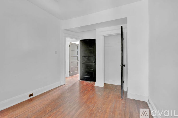 A room with a wooden floor and a door on the right.