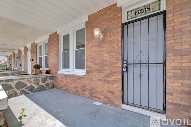 A brick building with a black gate and a window with bars.