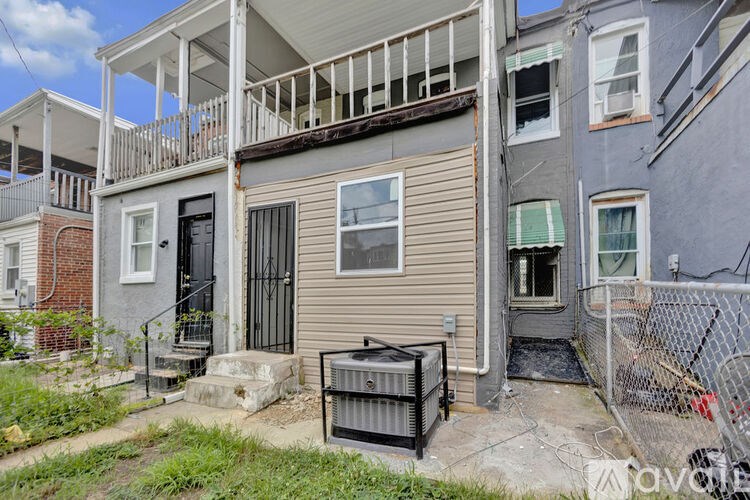 A house with a grey facade and a black gate.