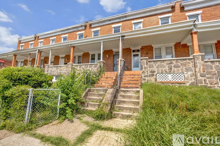 A red brick building with a white roof and a stone wall.