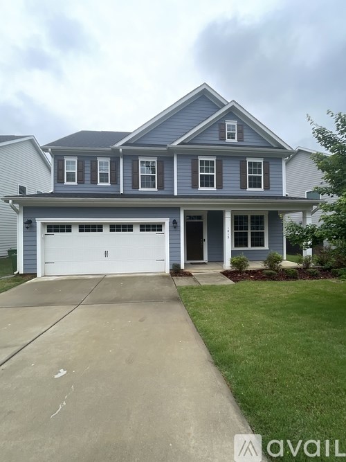 A two-story house with a garage and a driveway.