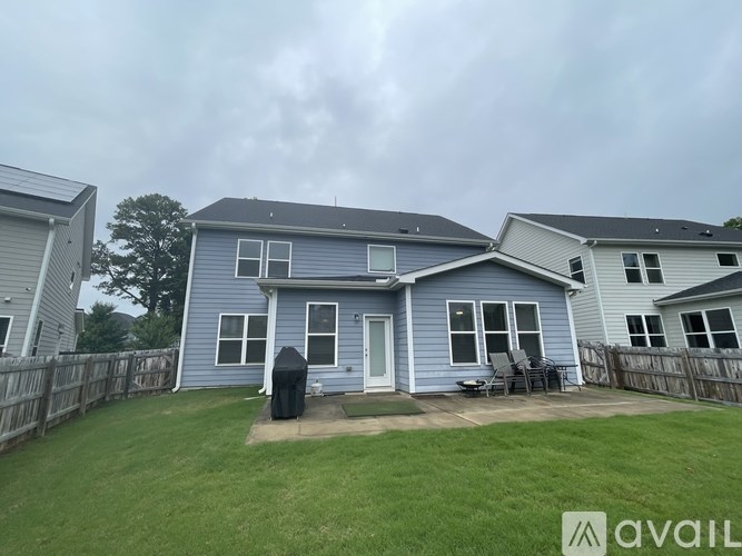 A blue house with a grey fence and a green lawn.