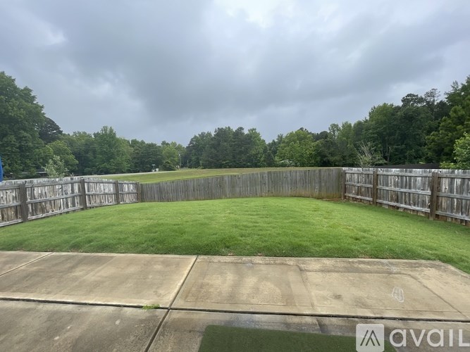 A backyard with a concrete slab and a wooden fence.