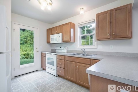 A kitchen with wooden cabinets and a white fridge.