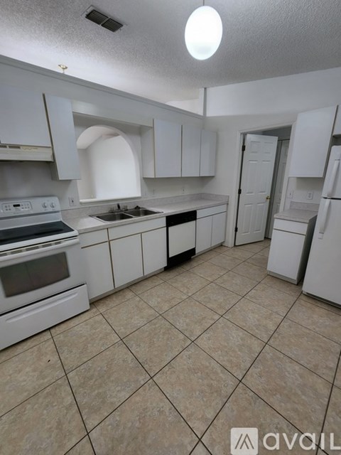 A kitchen with white appliances and cabinets.