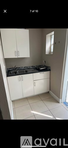 A kitchen with white cabinets and a black countertop.
