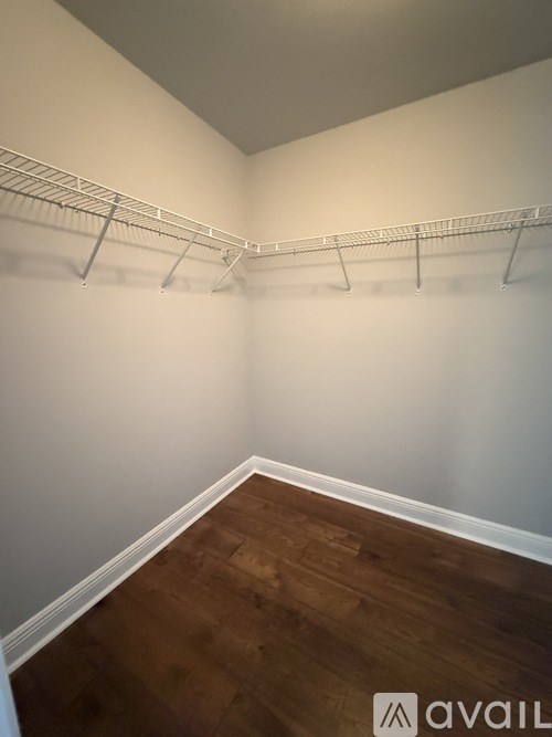 Empty room with white walls and wooden floor.