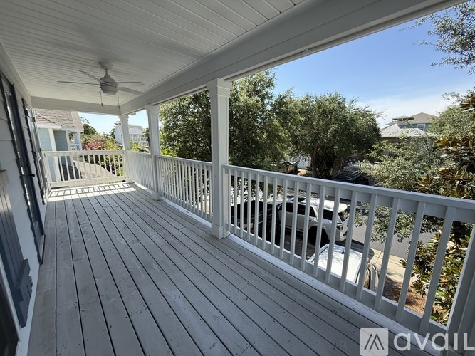 A balcony with a white railing and a ceiling fan.