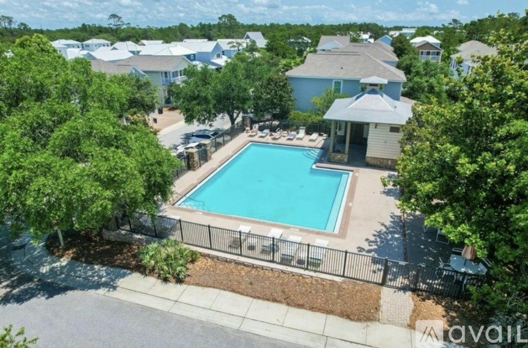 A swimming pool surrounded by a fence and trees.
