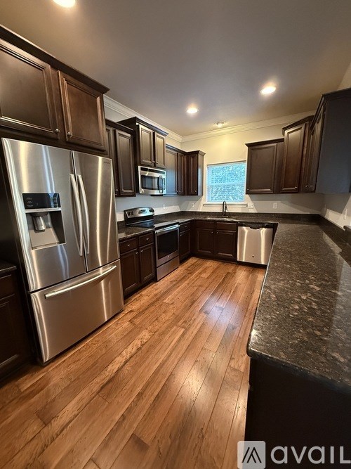 A kitchen with wooden floors and stainless steel appliances.