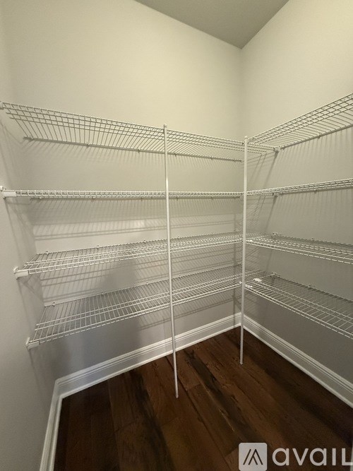 Empty shelves in a room with wooden flooring.