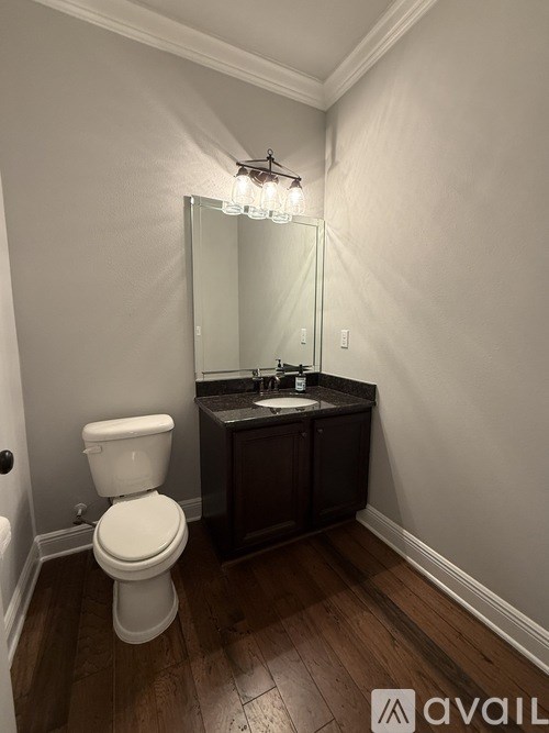 A bathroom with a toilet, sink, and mirror.