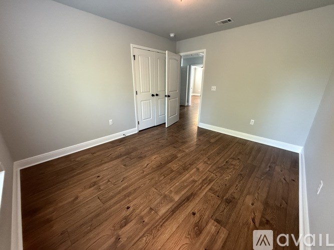 A room with wooden flooring and two doors.