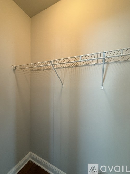 A white wall with a metal rack on it.