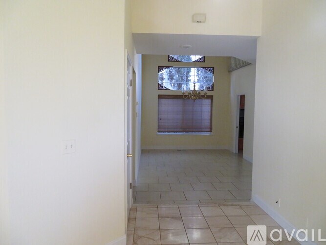 A hallway with tiled flooring and a doorway leading to another room.
