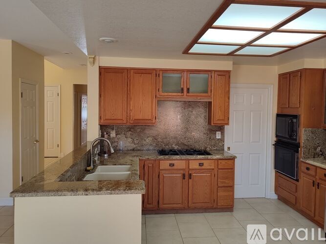 A chandelier hangs over a table in a room with a window.